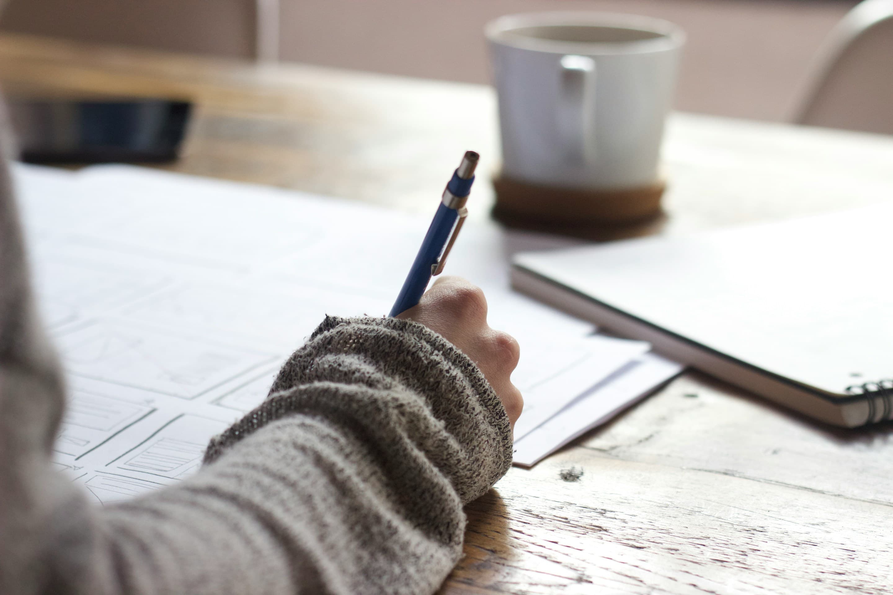 Student writing with coffee